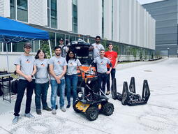 Team in front of Mitchell Hall with mobile robots