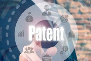 A hand pointing at the word patent while icons float in a circle around it