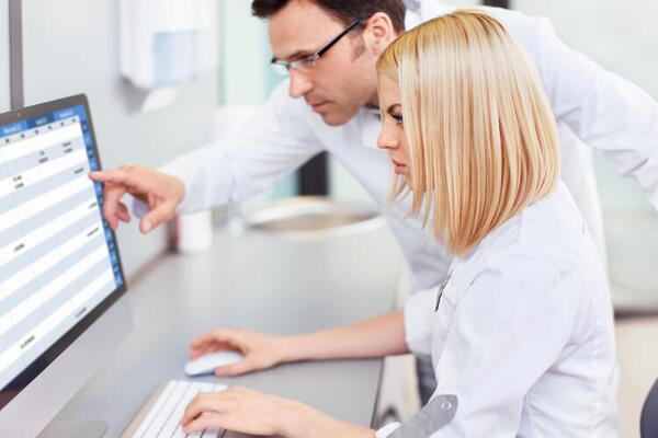 Two lab techs looking at monitor