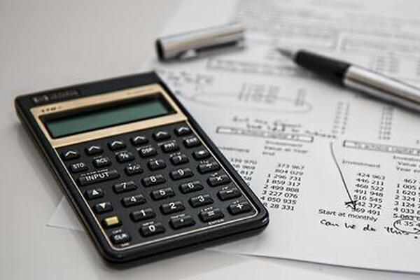 calculator on financial sheet with pen on a table