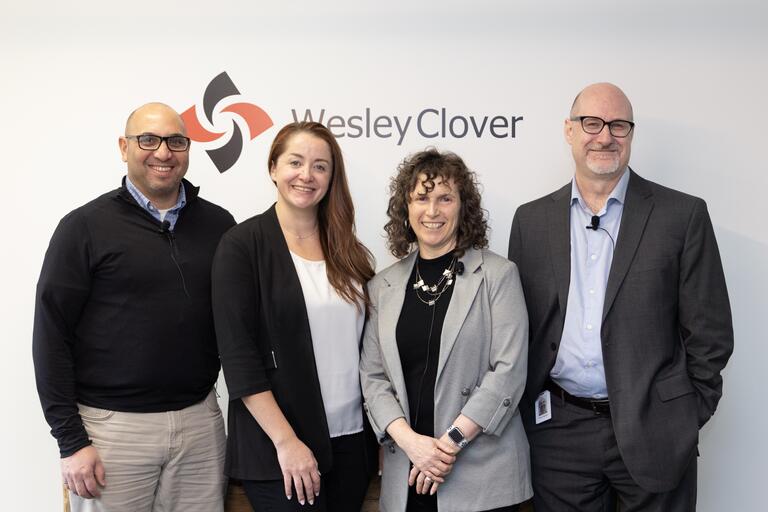 Hub350 panelists pose in front of a Wesley Clover wall