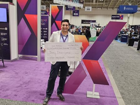 Prameet Sheth holding an award cheque at DiscoveryX