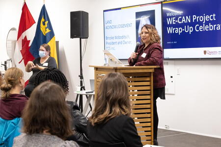 Brooke Woboditch standing at a lectern, speaking to a group of people
