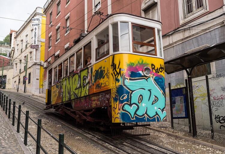 Straeetcar decending hill with garffiti on it