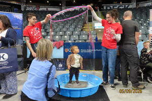 A young visitor experiences standing inside a giant soap bubble.