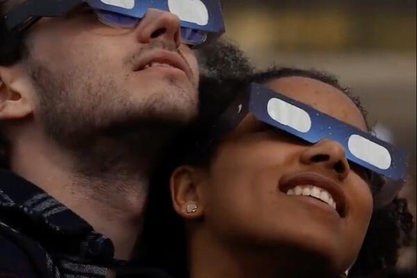 Two people viewing the total solar eclipse in Kingston, Ontario on Queen's Campus