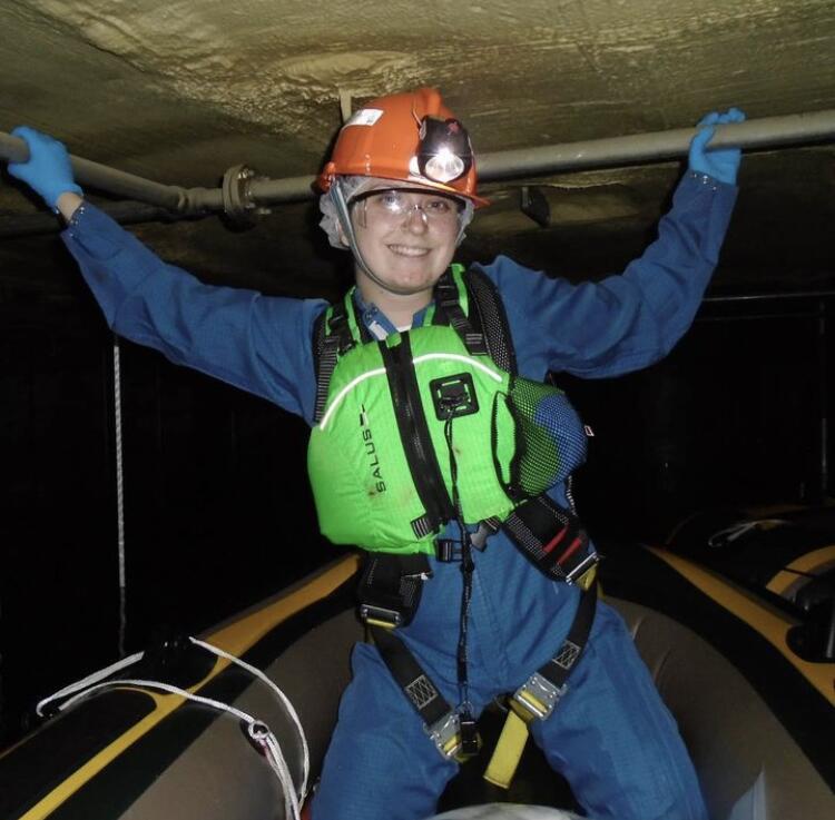 inside the SNO+ cavern. Boats are used to navigate since the cavern is filled with water. In the background one of the detector hold up ropes is visible. 
