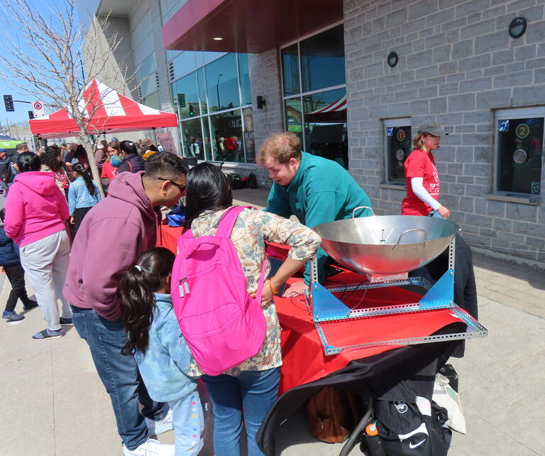 Volunteer Felix Thiel explains the radio telescope at the 2026 Science Rendezvous Kingston.