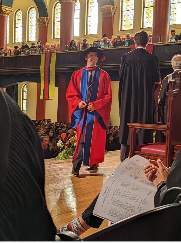 Connor Stone on stage receiving his PhD degree at Grant Hall, Queen's University