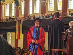 Connor Stone on stage receiving his PhD degree at Grant Hall, Queen's University
