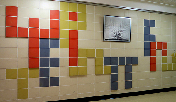Mural depictions of Greek letters and other symbols used in physics on a wall of Stirling Hall