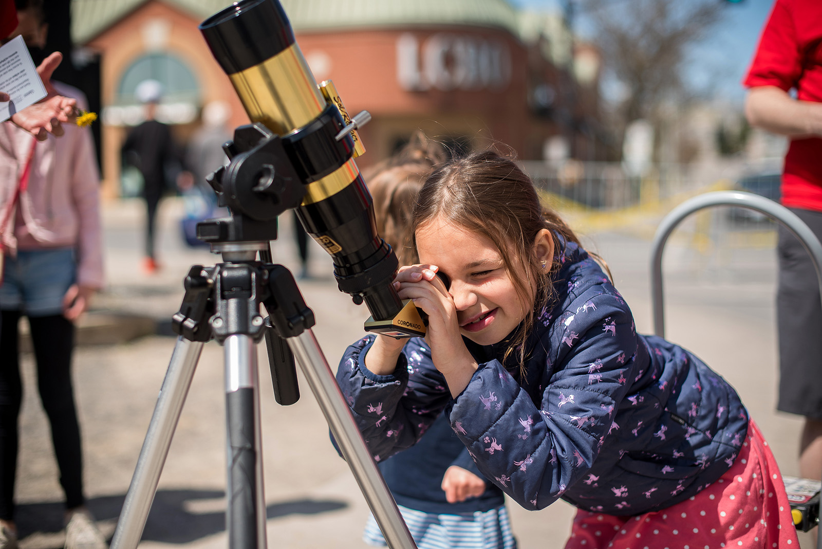 Child looking through the telescope at Science Rendezvous Kingston