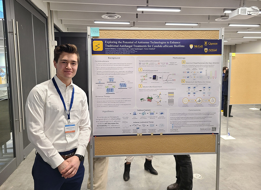 Ciaran Byles-Ho in front of the team's winning poster at the 2024 SCINAPSe research competition held in Ottawa.