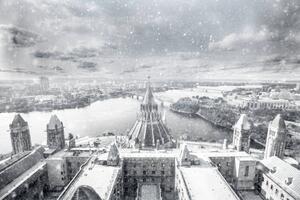 photograph of the Canadian parliament buildings in winter, overlooking the Ottawa River