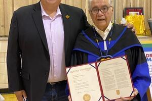 Raymond Mason holding his honorary degree from Queen's University standing next to his son Kyle Mason.