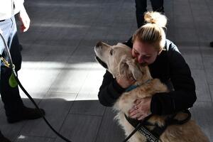 Blonde haired girl hugging Oscar the dog