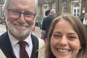 Queen's Principal Patrick Deane (man with white hair and glasses) wearing formal robes, smiling with Queen's Rector Niki Boytchuk-Hale (woman with light brown hair wearing blue shirt)