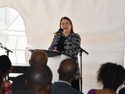 woman speaking into a mic at a podium