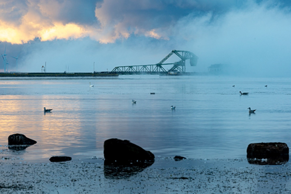 foggy lake ontario with bridge in the background