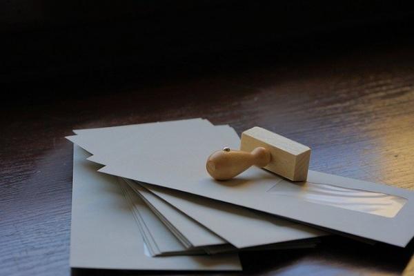 Stack of envelopes with a wooden stamp on top