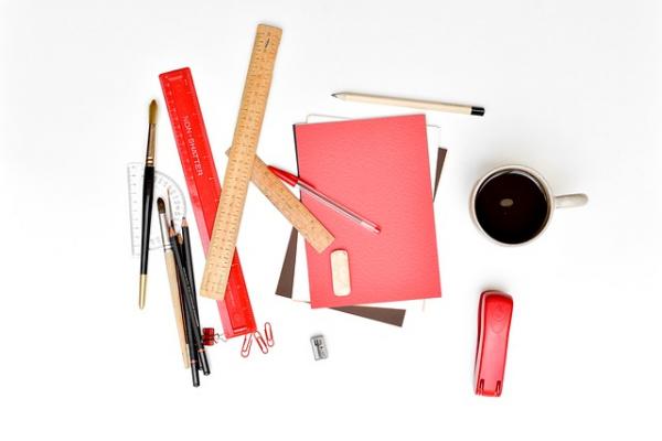 Overview of a bunch of office supplies in a pile, rulers, pens, pencils.