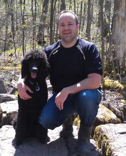 Photo of Michael Rauh with his dog in a forest