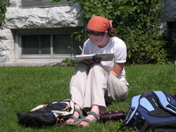 A person sitting outside writing in a book