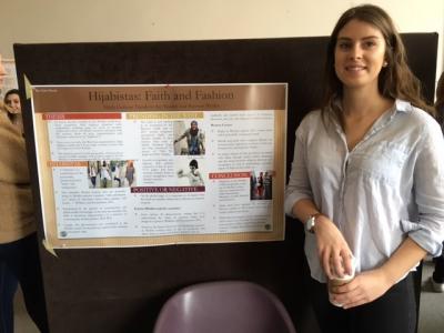 A person standing beside a poster