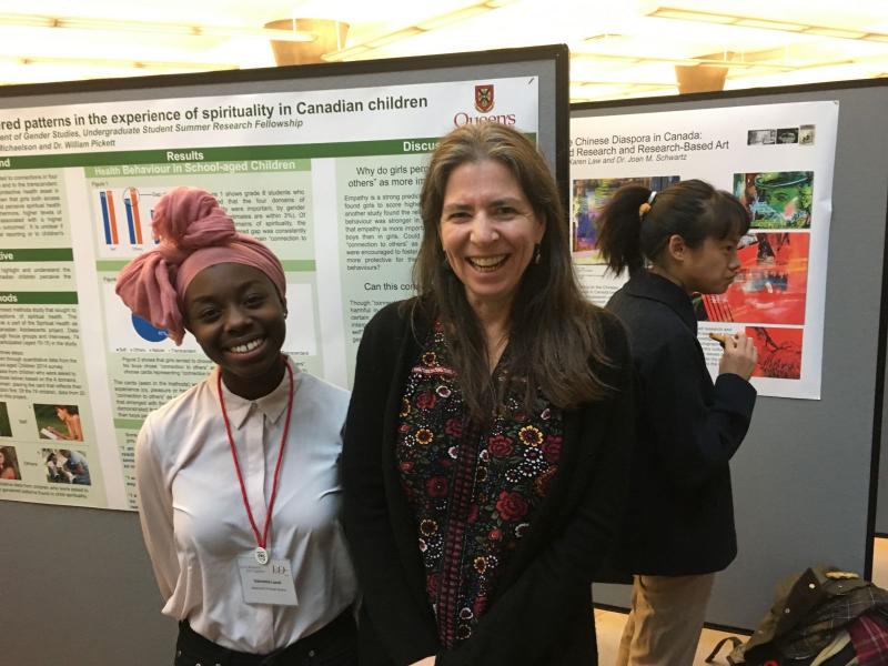 People smiling for a picture in front of a poster