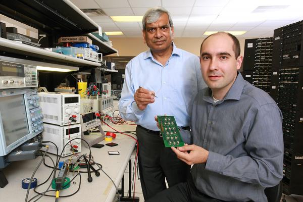 [Photo of Praveen Jain and Marko Krstic at the ePOWER lab at Queen's.]