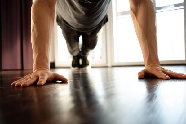 [Man performing a push-up indoors]