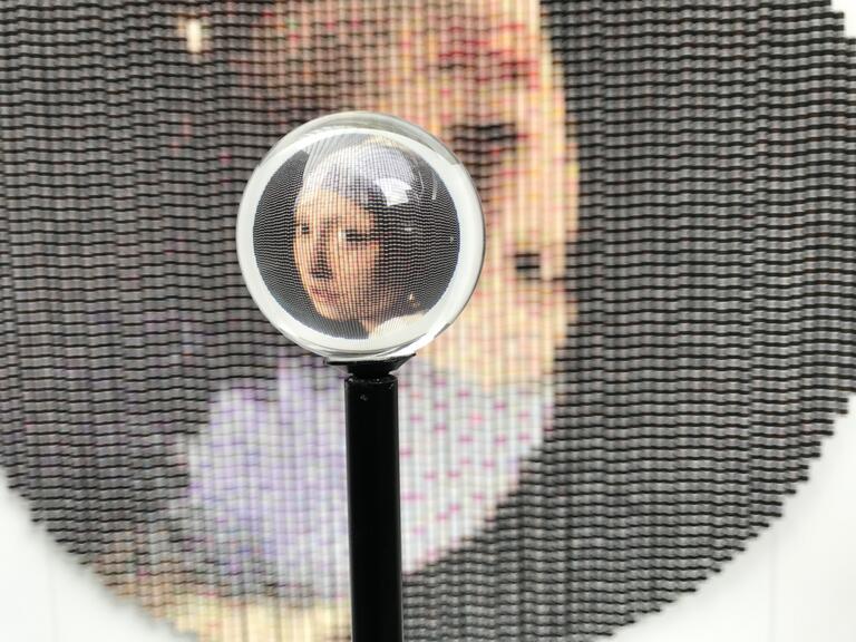a magnifying glass over the famous painting "Girl with a Pearl Earring"