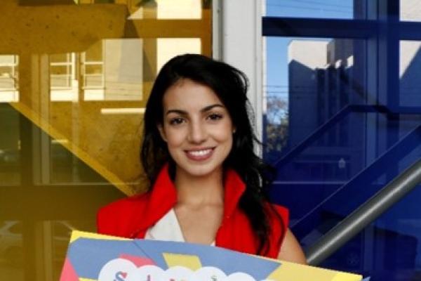 Student staff smiling holding a sign that says "student development". 