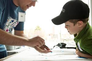 Adult demonstrates graphene production to an attentive child.