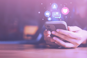 Hand holding phone with social logos