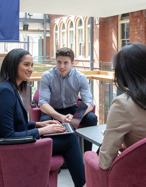 Three Smith students gathered around a table talking