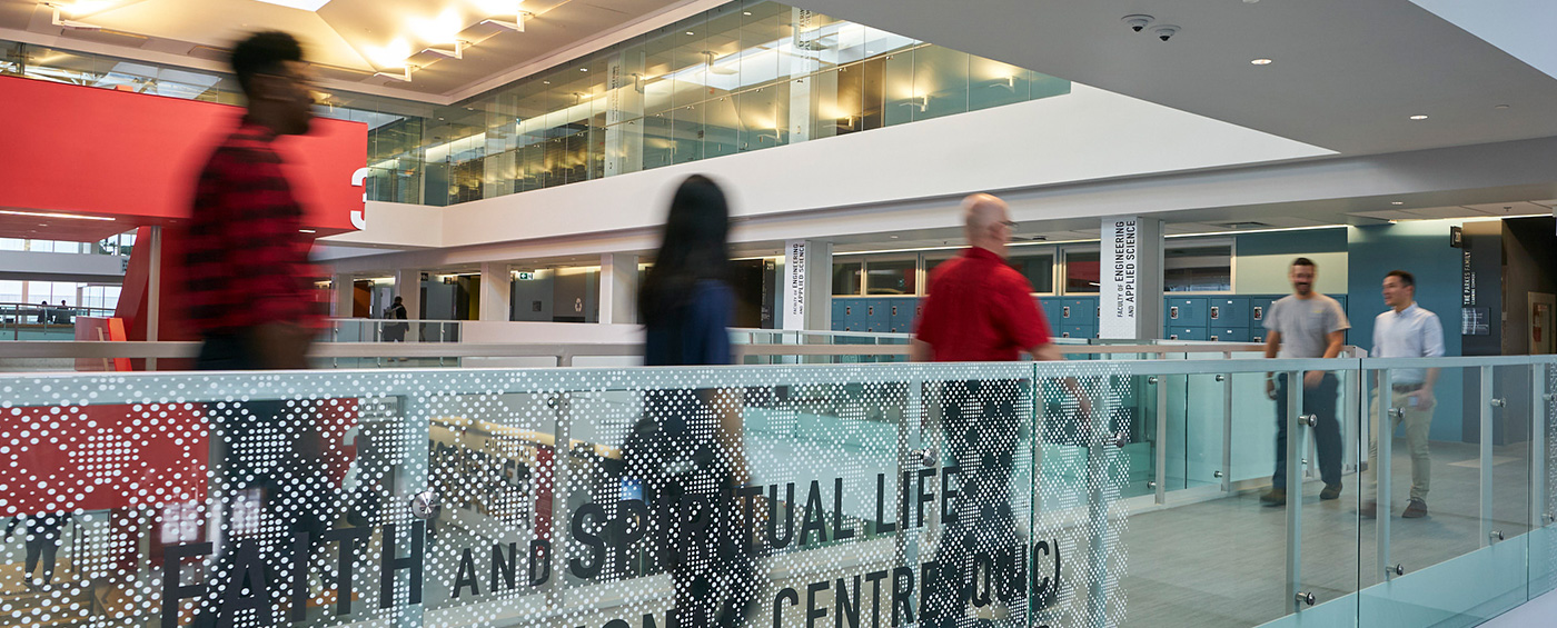 Staff and faculty with motion blur walking through Mitchell Hall