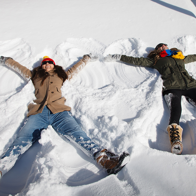 [people in the snow making snow angels]