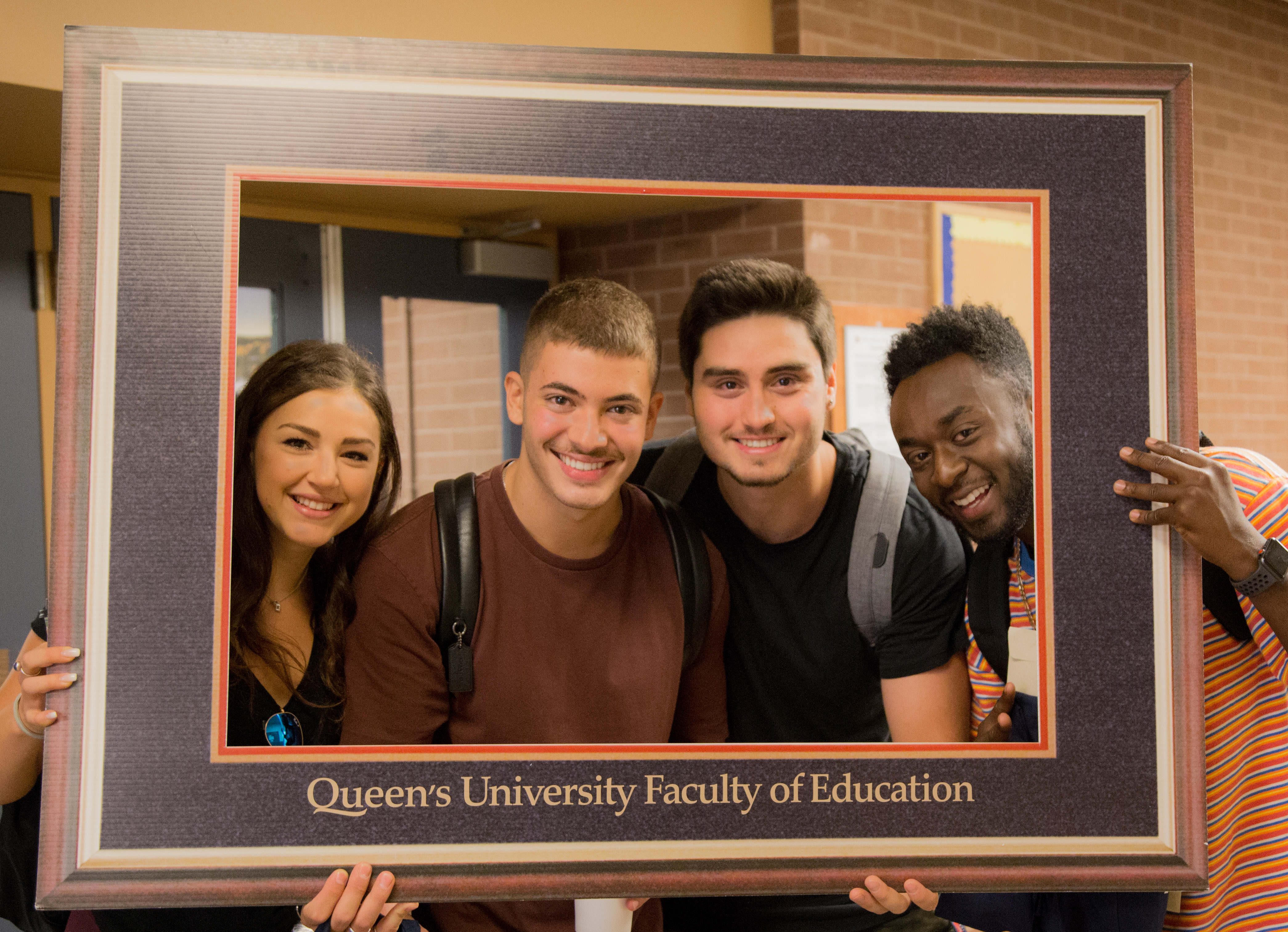 4 Students look through a picture frame