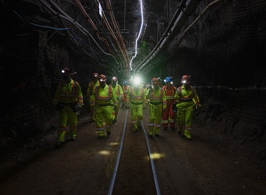 Group of people walking through underground tunnel researching dark matter mysteries