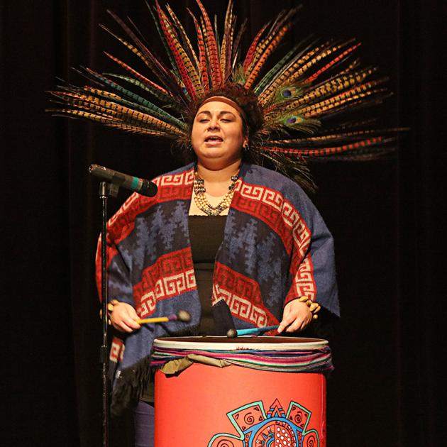 [a person performing on a drum in traditional clothing]