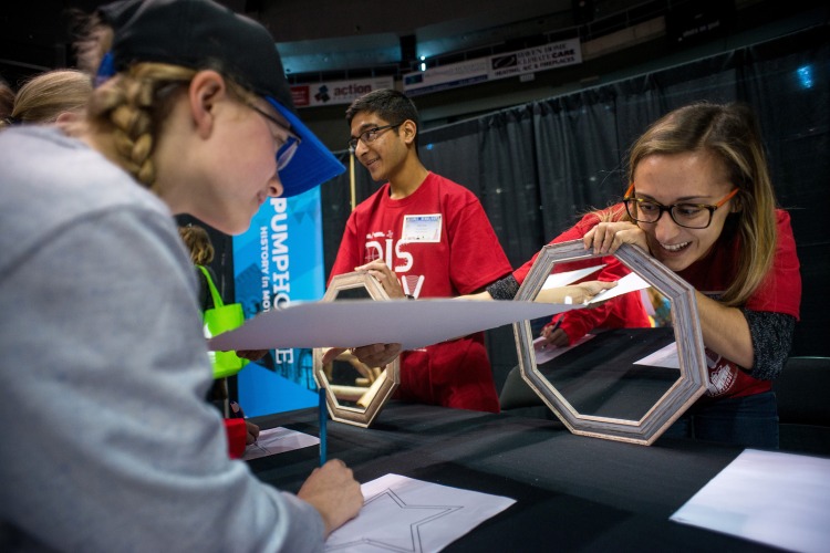 [Photo of Queen's researchers and students engaging with young students at Science Rendezvous Kingston]