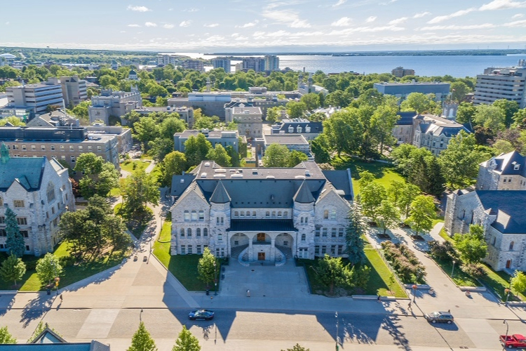 [Aerial photo of Queen’s University campus capturing buildings along Union Street, including Douglas Library, Ontario Hall, and Grant Hall in the foreground.]