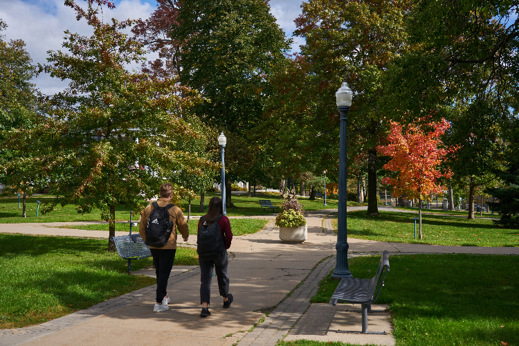 [Students walk down Professors’ Walk on Queen’s University campus. ]