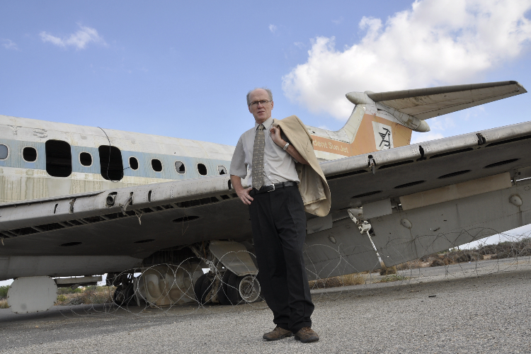 [Dr. John McGarry stands in front of a Trident Sun jet at the Nicosia airport in Cyprus. ]