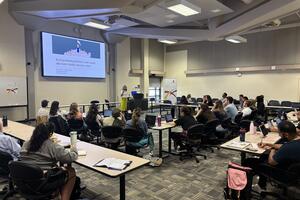 Students listening to speaker in a room
