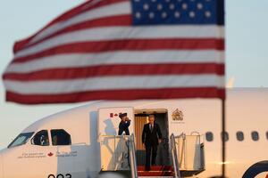 Mark Carney, stepping off a plane, with an American flag in the foreground. Adrian Wyld/The Canadian Press