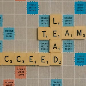 Scrabble board that reads lead, team, succeed. 