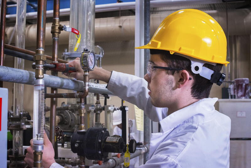 Male student in hard hat chem pilot plant