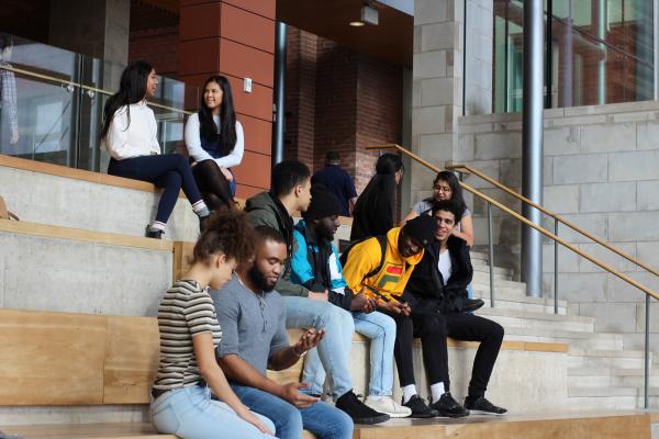 Groups of students sitting on steps in Goodes lobby